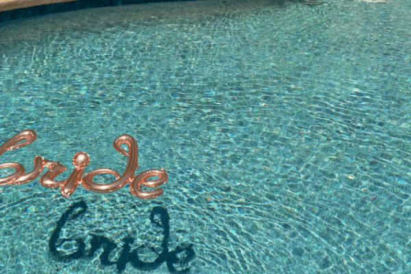 A pool with a floating balloon spelling 